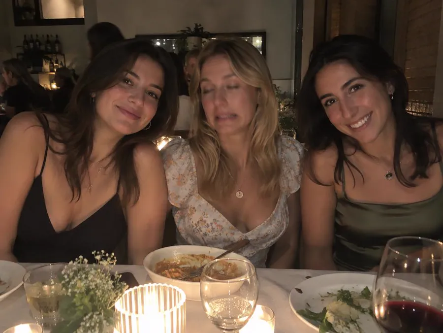 Take 1: three friends at a candlelit dinner table, the woman in the middle with half-closed eyes and a grimace